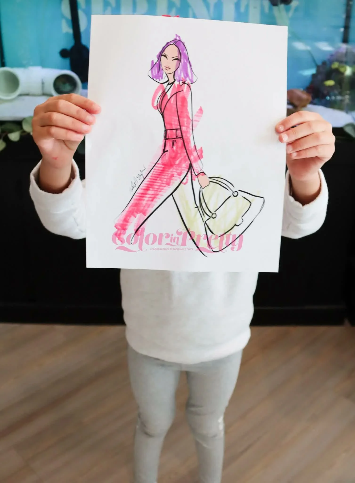 A child holding original Color In Pretty Dollie artwork